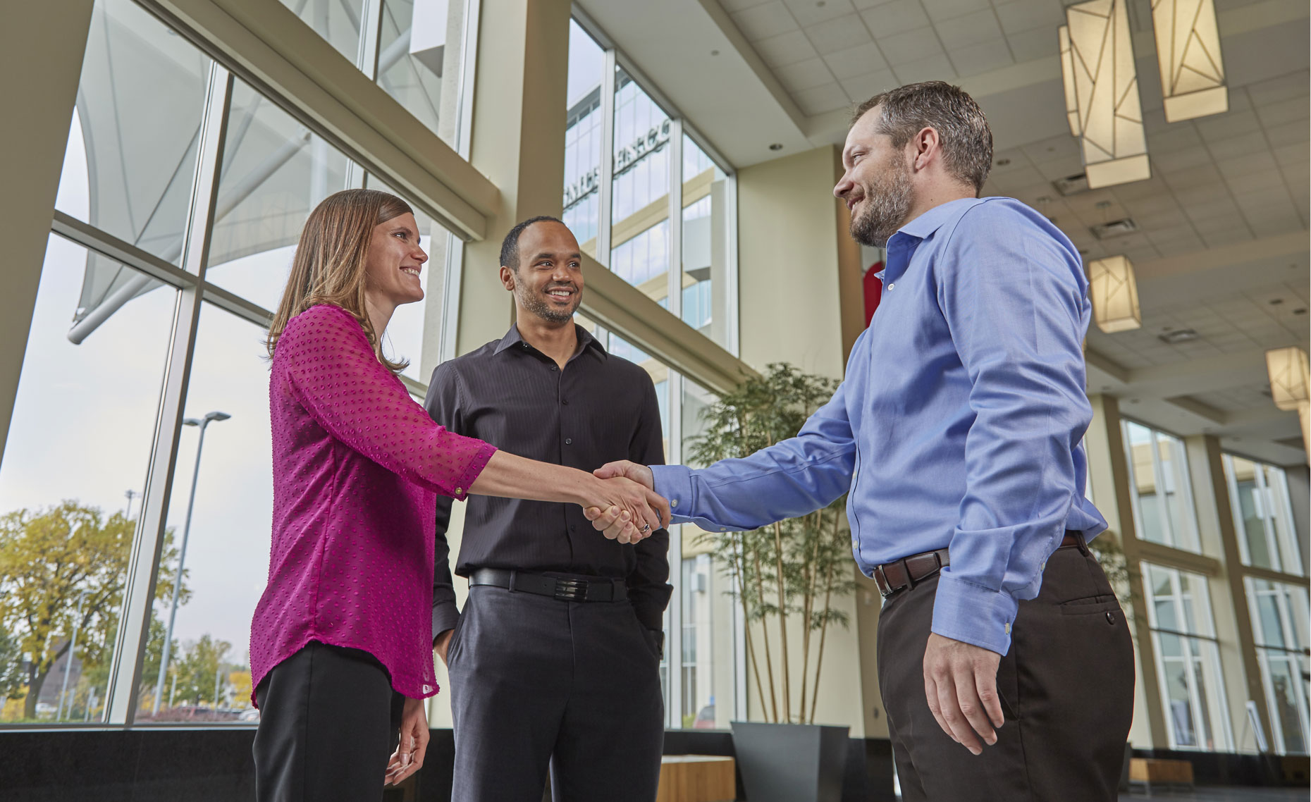 Man/woman/shaking hands/business lobby/lifestyle photography