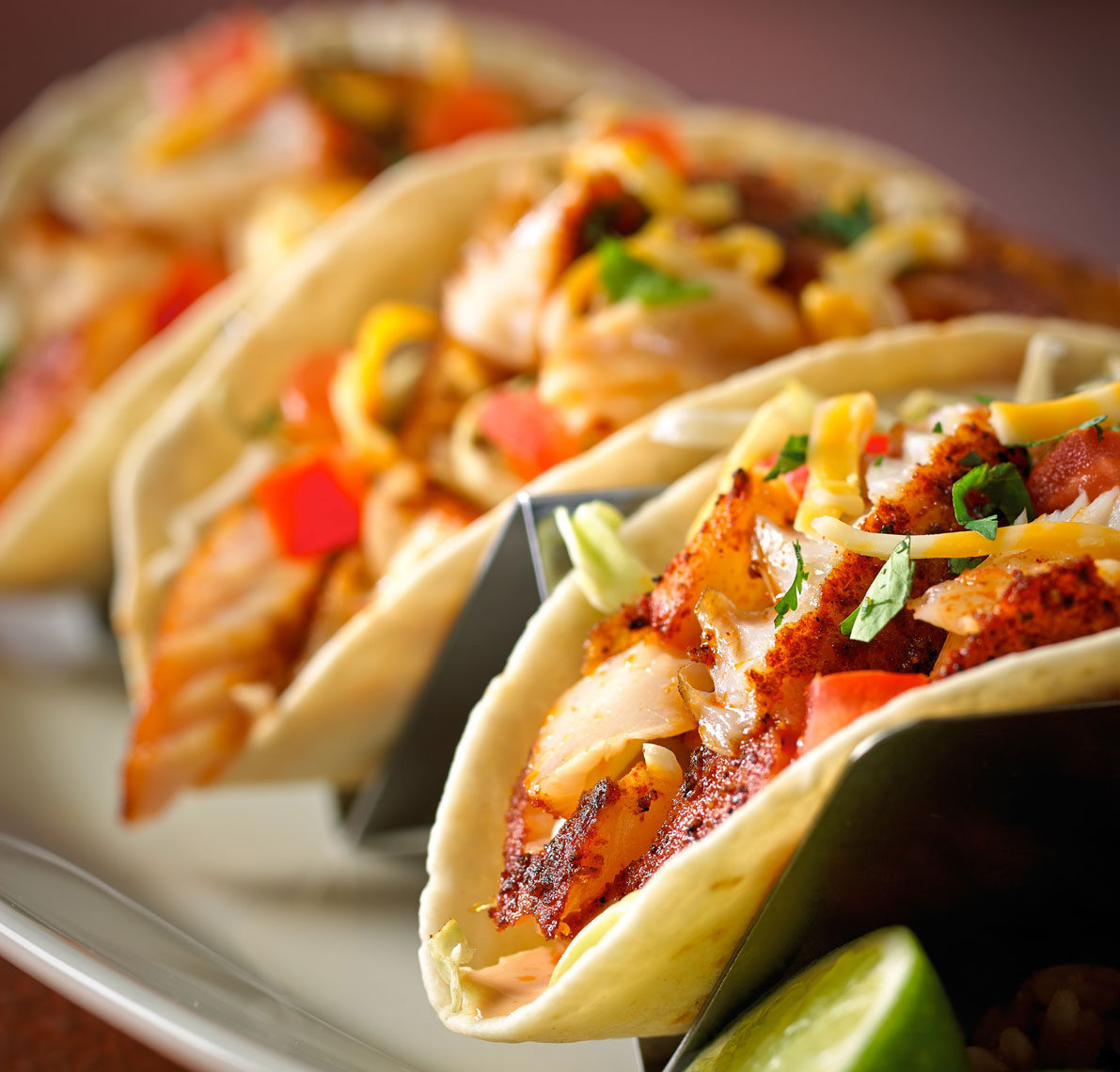 3 fish tacos in holders/veggies/cheese/food photography
