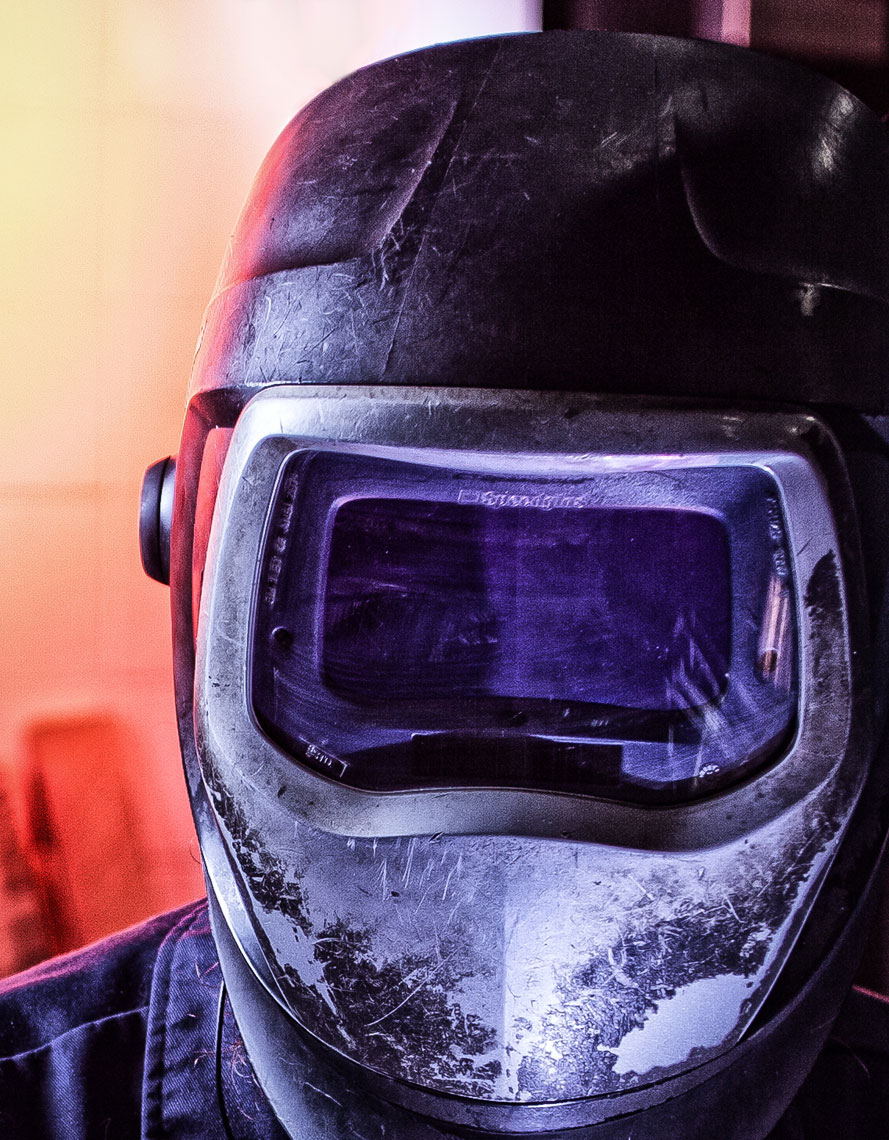 Welder portrait/purple light/close up/industrial photography