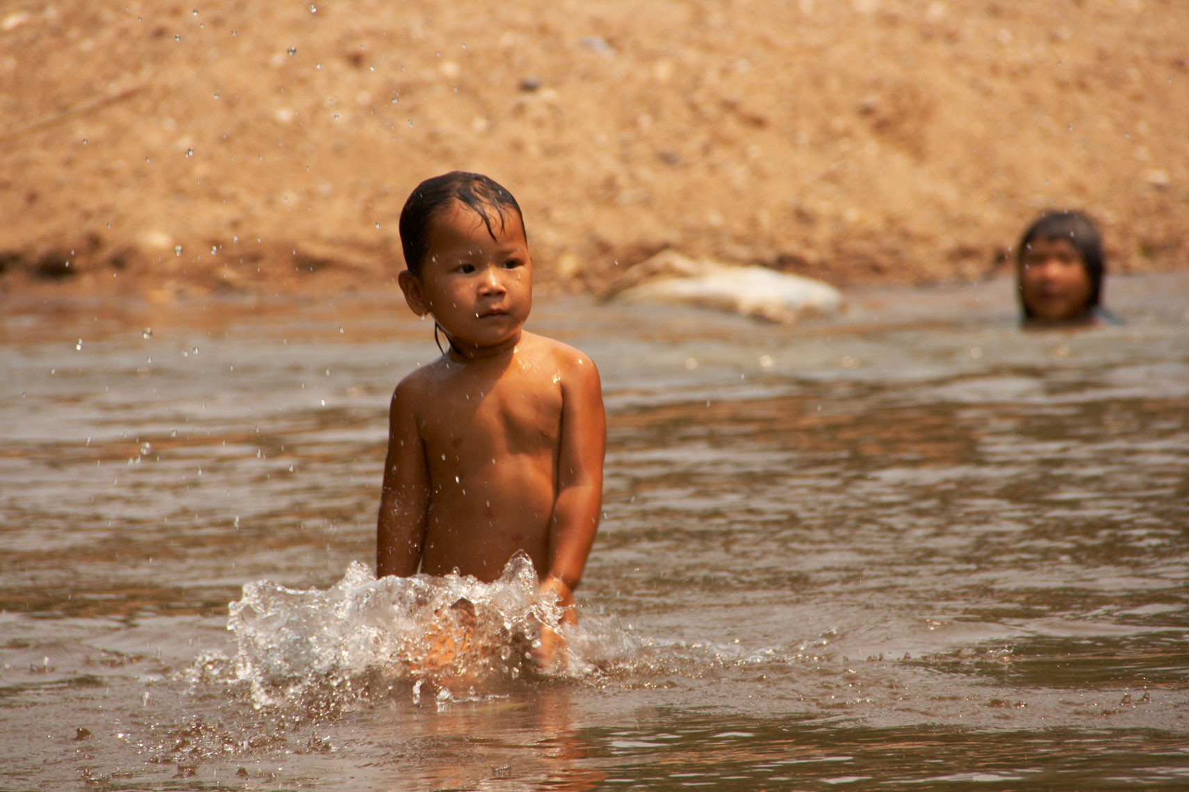 Young boy/swimming/river/Thailand/location photography