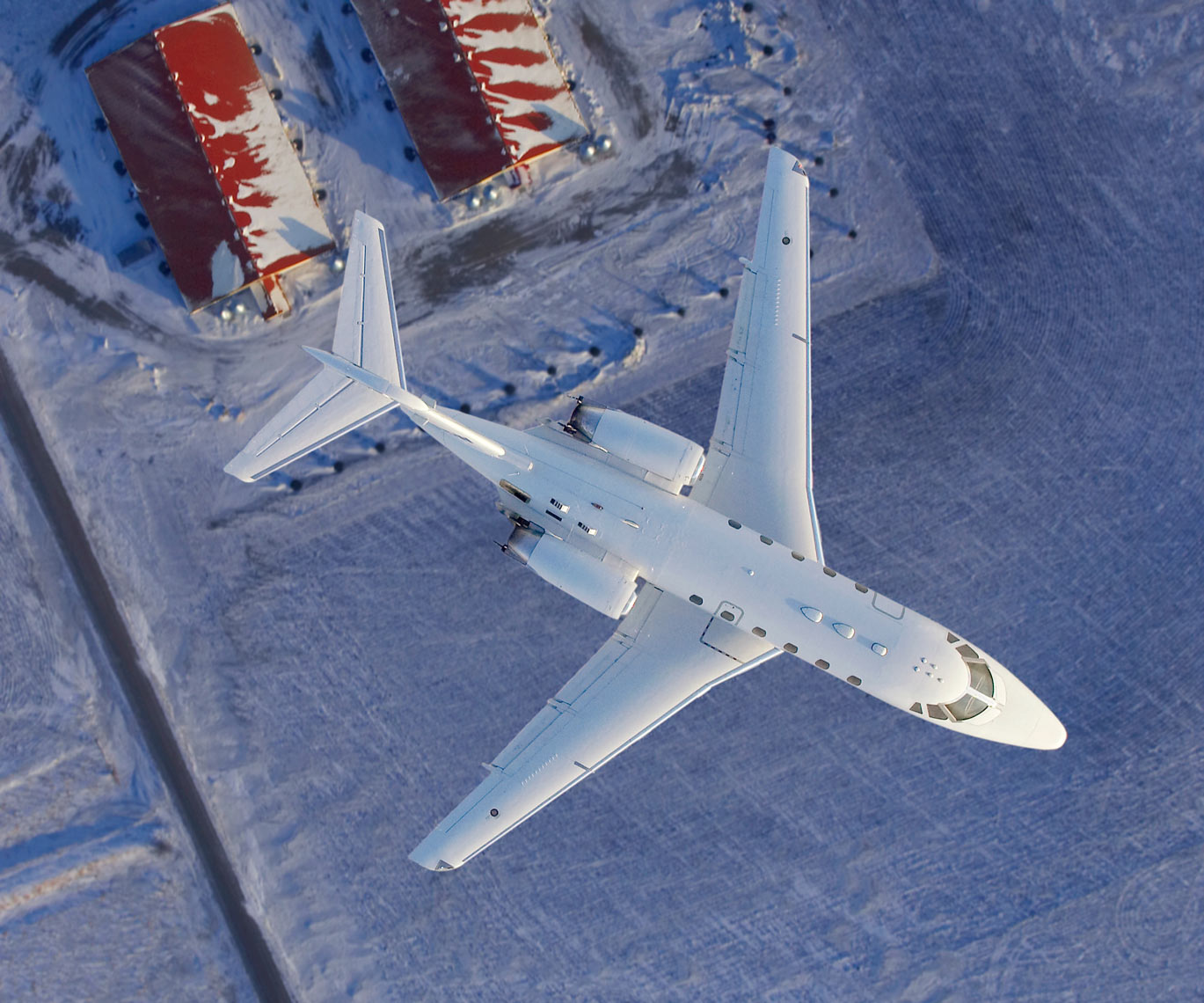 Jet flying over snow field/red barns/aviation photo