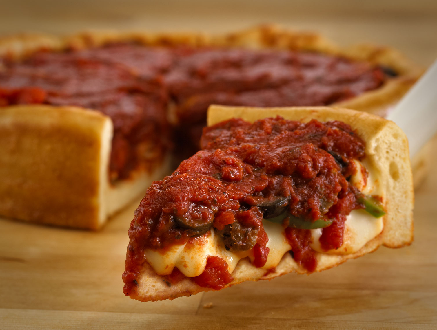 Deep dish pizza/piece/server/foreground/food photography