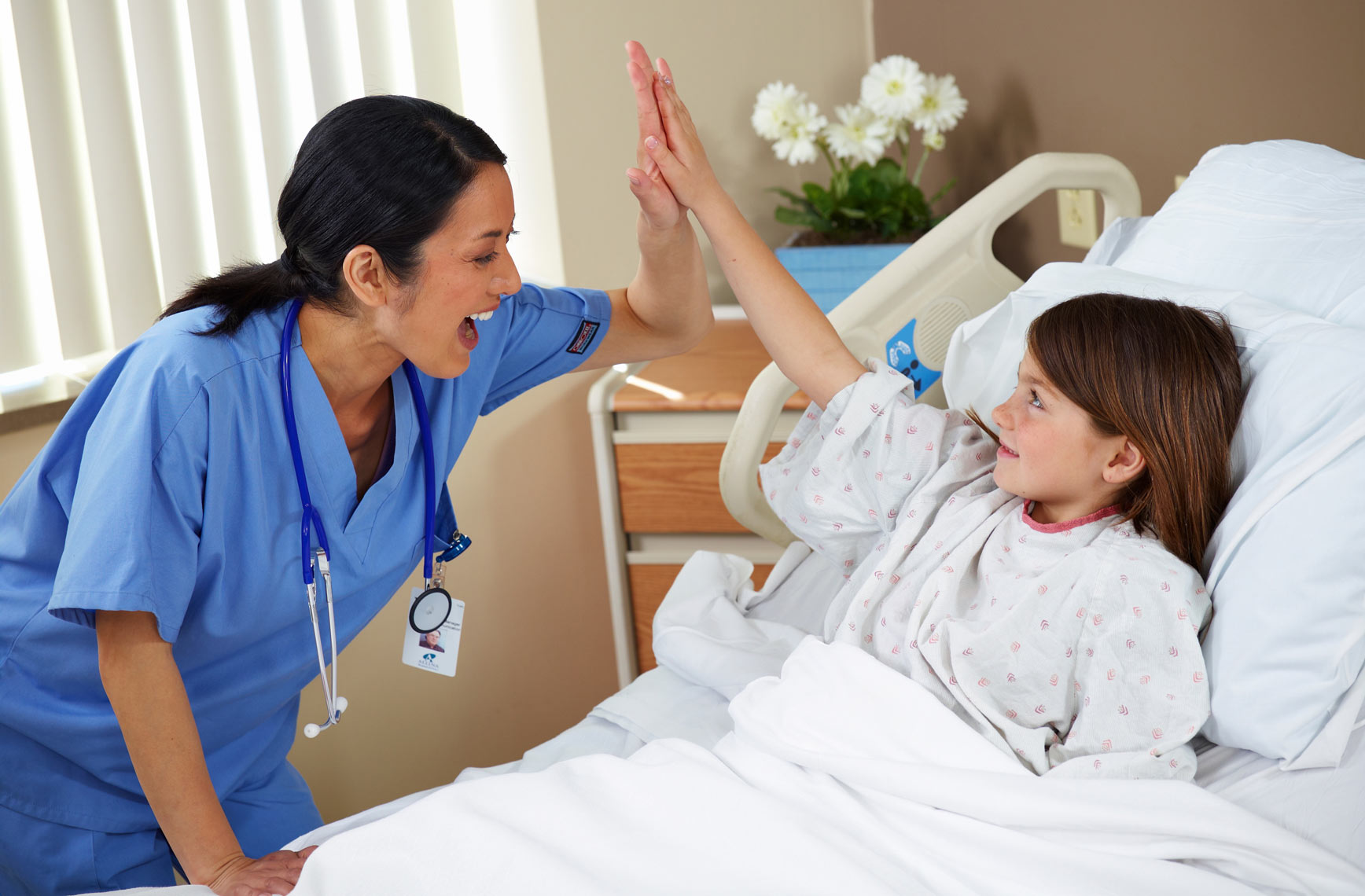 Nurse/blue scrubs/high five/girl patient/medical photography