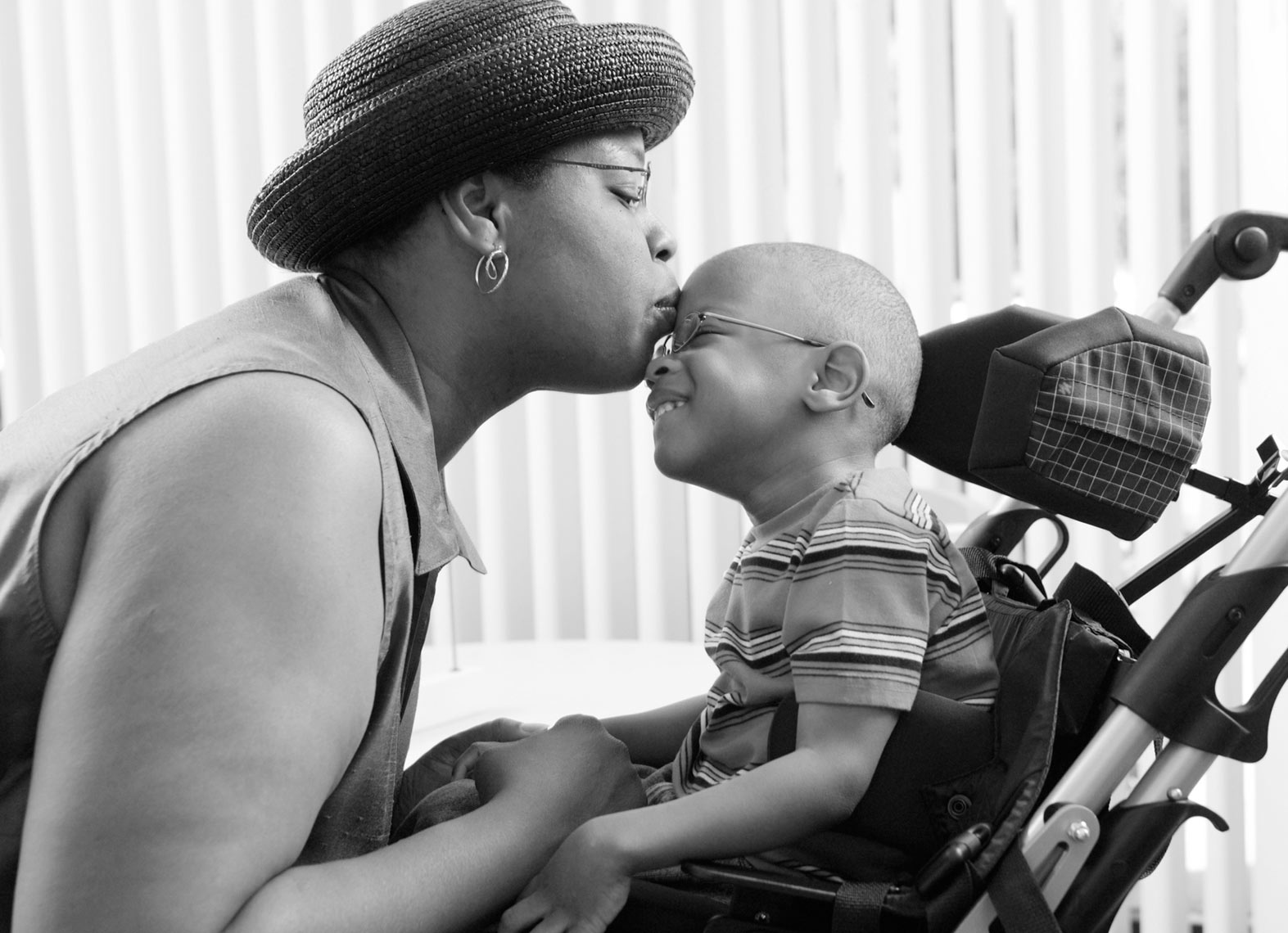 Black mom/kissing child/wheelchair/medical photography